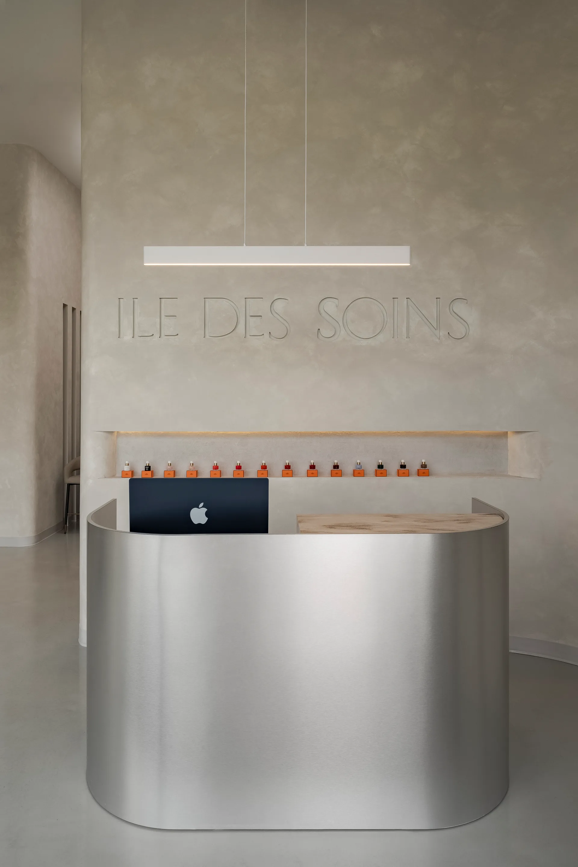 Rounded metal reception desk against a textured wall