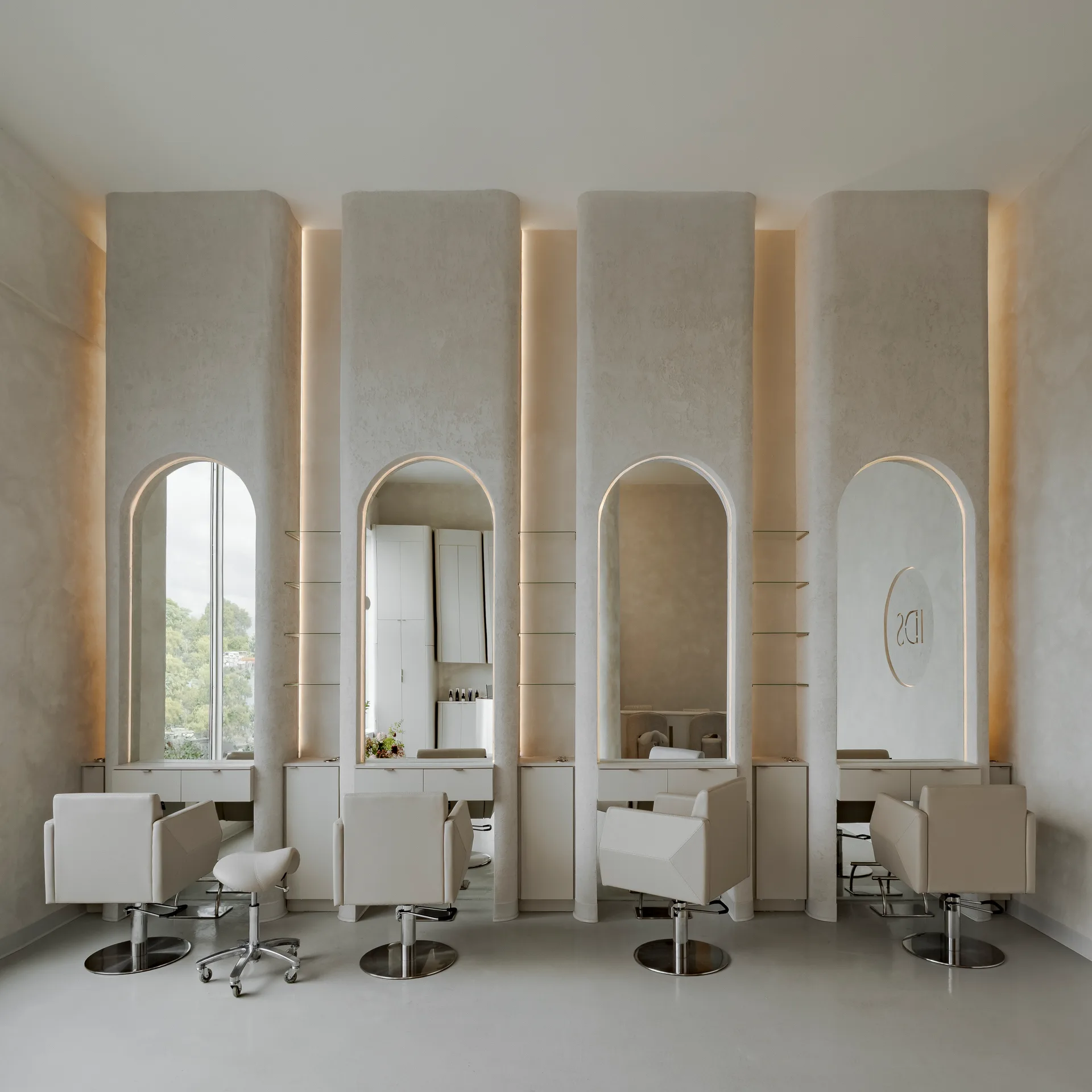 Salon stations with arched mirrors and pale chairs