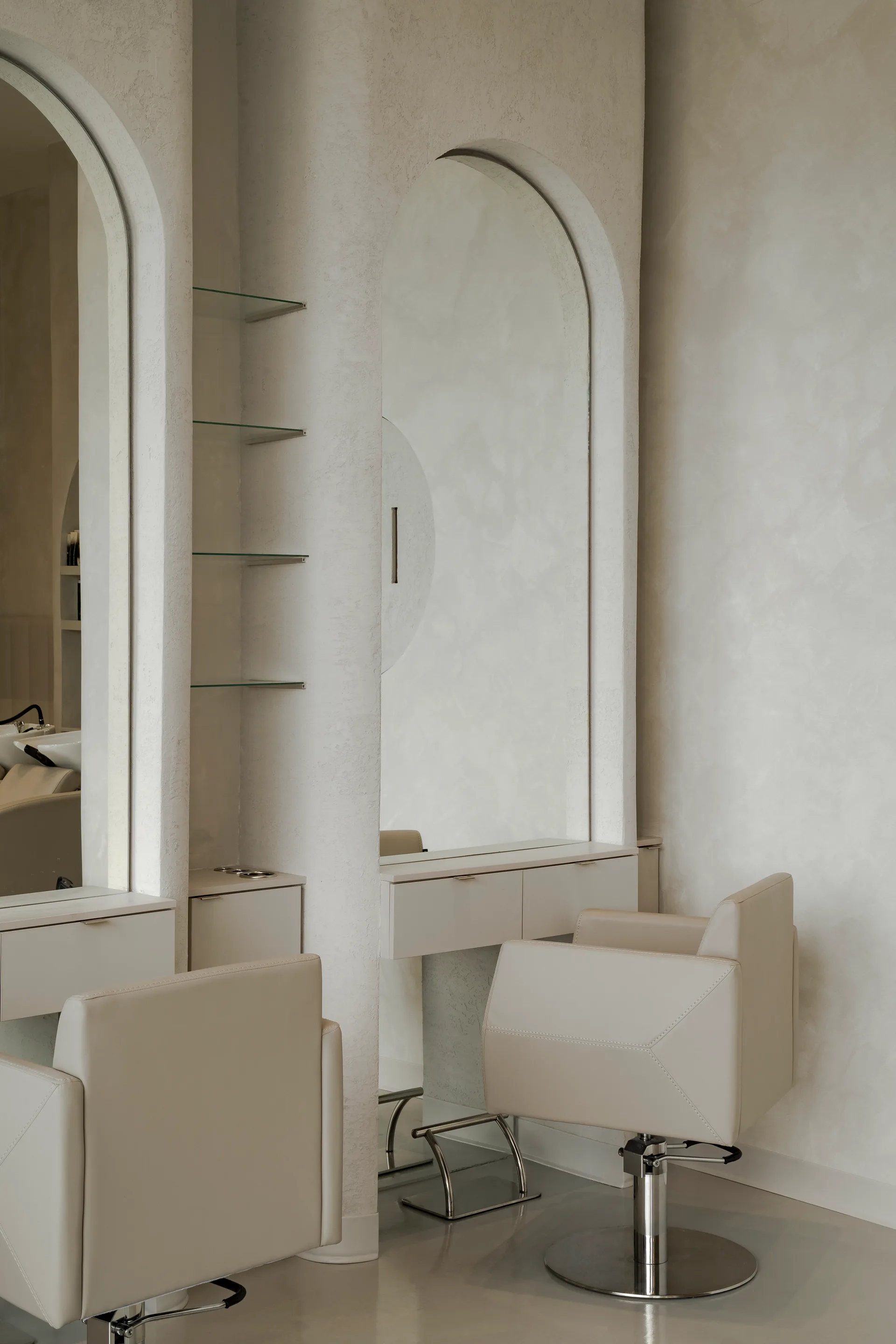 Salon chair beside a tall arched mirror