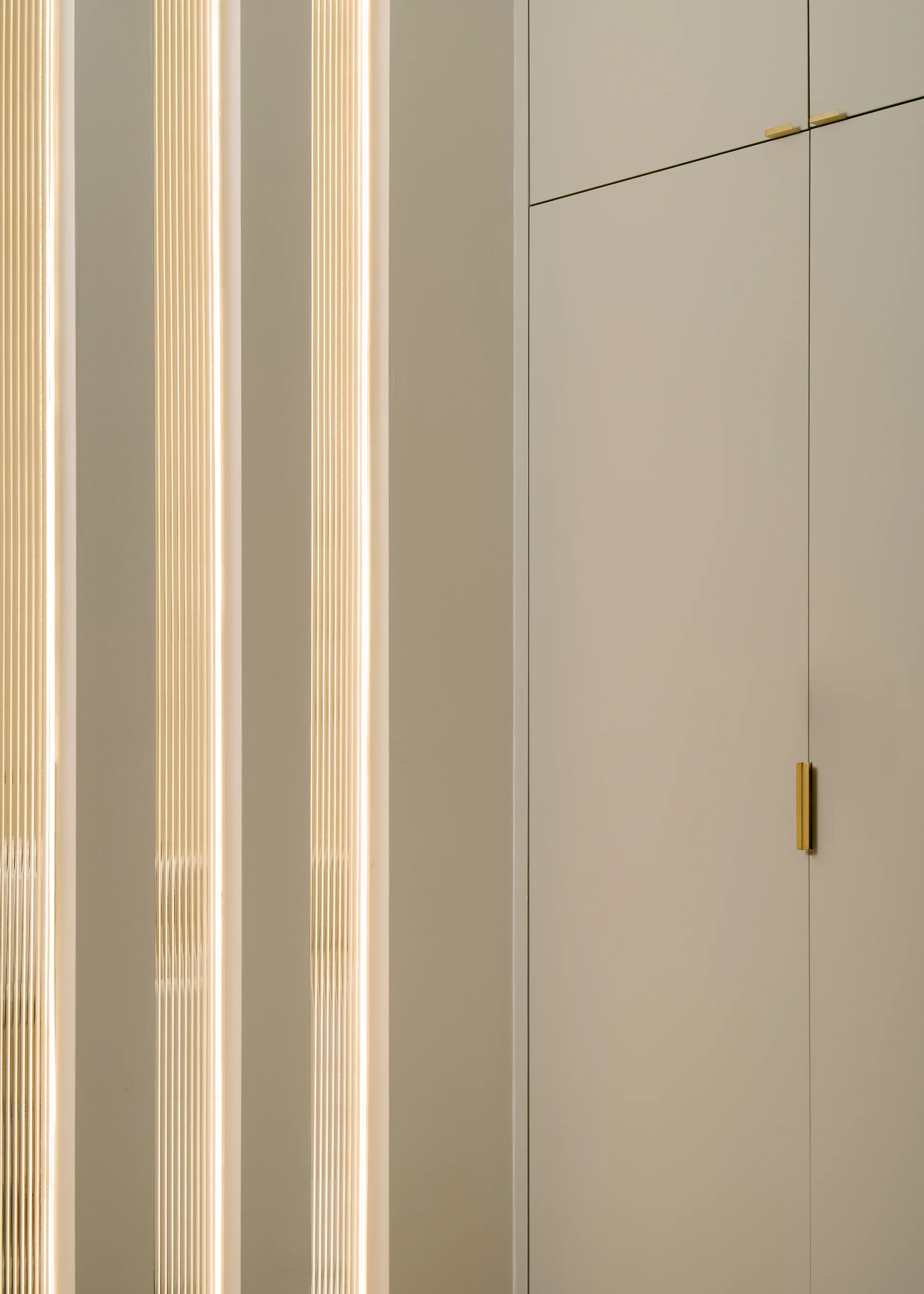 Detail of pale cabinet doors and warm lighting
